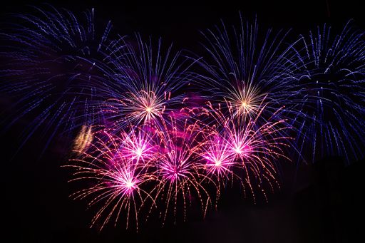 Bright festive fireworks. Light rays on a dark sky background. Abstract rays of light.