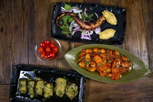 A high angle shot of a grilled octopus and potatoes with different vegetables