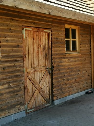 A vertical shot of an old door and window on a wooden house