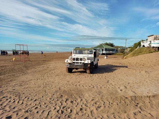 Front view of an old off road jeep in the sand of the beach