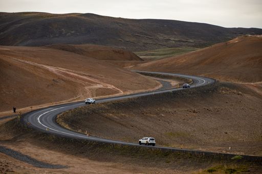 The two vehicles drive along a winding highway
