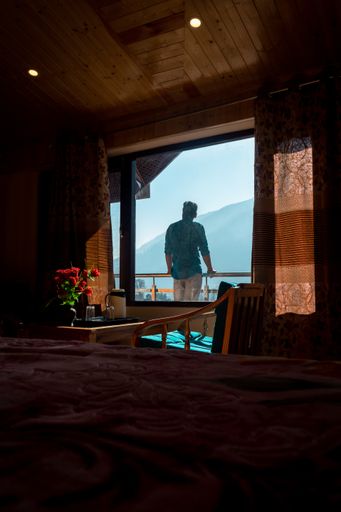 A lonely person enjoying the beautiful balcony view in a hotel room