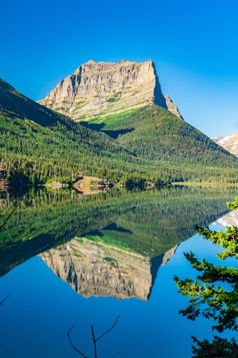 A vertical shot of the mountain reflection in the water at Glacier National Park, Montana