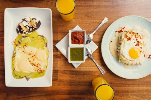 A top view of a healthy breakfast table for two with fresh egg dishes served with orange juice