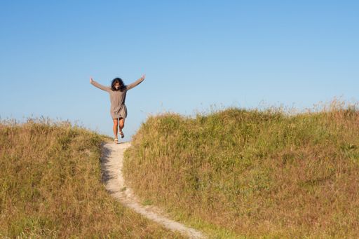 An excited female in a facial mask going down the hill path - a new normal concept
