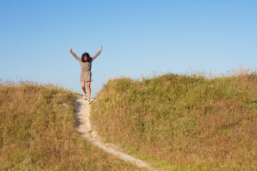 An excited female in a facial mask going down the hill path - a new normal concept