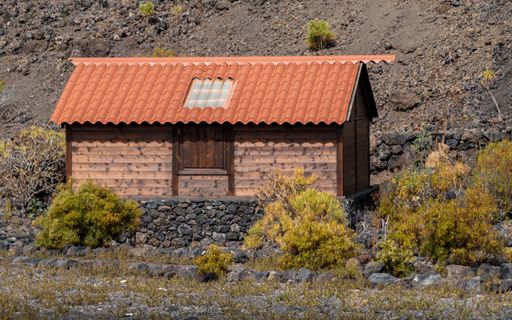 A closeup shot of a beautiful wooden house surrounded by shrubs