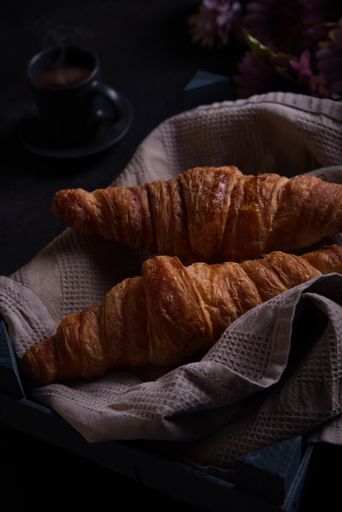View from above of two croissants with a cup of coffee.