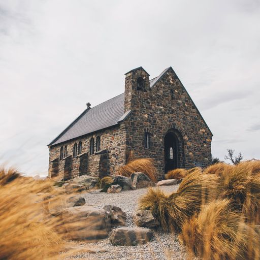 A breathtaking view of a church situated near a tranquil lake in Tekapo, New Zealand.