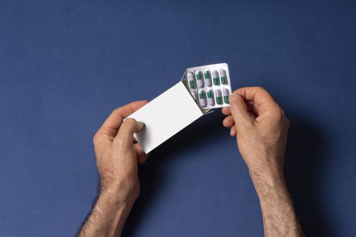 Male hand putting a capsule pills tablet in a box