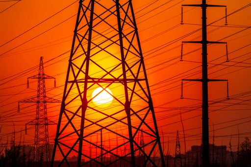 A closeup shot of high voltage electricity transmission towers at sunset