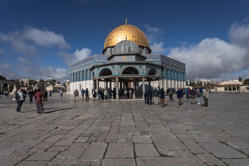 A group of people in front of the Dome of the Rock in Jerusalem