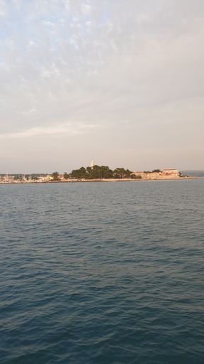 A vertical shot of a beautiful blue tranquil sea under a cloudy sky