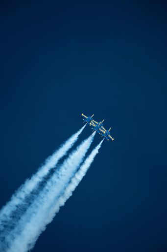 Blue Angel Navy jets flying vertically in formation with smoke trails behind creating a dynamic scene