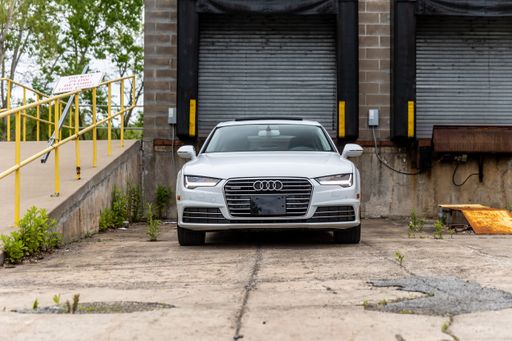 Two automobiles are parked in front of an abandoned building located near a set of stairs