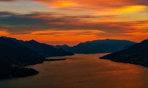 A beautiful shot of a colorful sunset over a lake with mountains