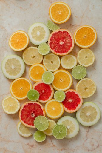 A vibrant display of citrus fruits consisting of limes and lemons in various on a wooden table