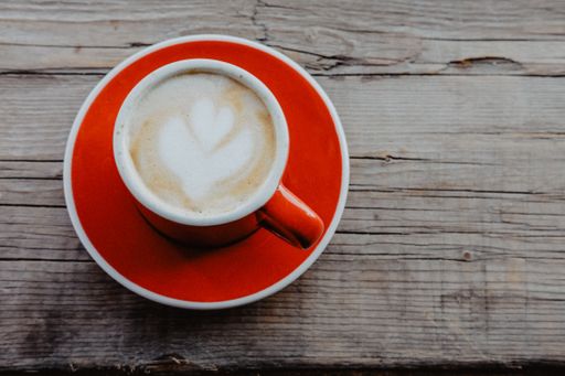 A top view of a mug of cappuccino on a wooden surface