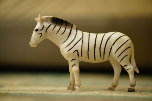 A closeup shot of a toy of a zebra in a room