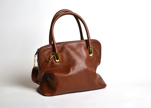 A closeup studio shot of a brown leather handbag on white background