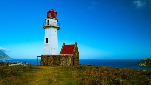 A scenic view of a lighthouse perched atop a hill in Batanes, Philippines