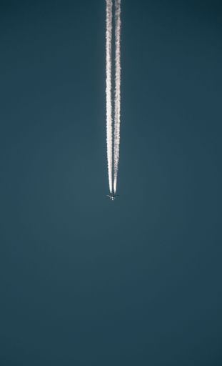 A jetliner soaring across the sky, leaving a bright and long contrail trail