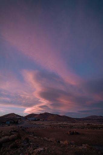 A fascinating vertical shot of a pink sunset above a village