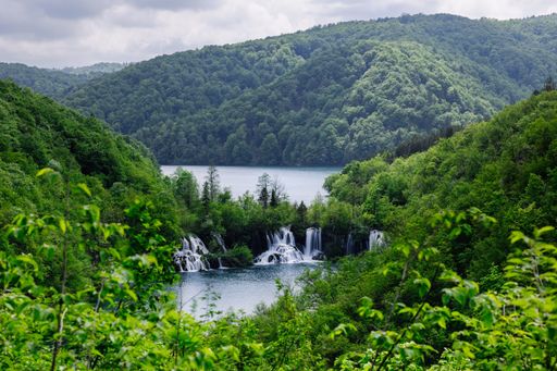 A tranquil scene of the Plitvice Lakes in Croatia with waterfalls surrounded by lush green foliage