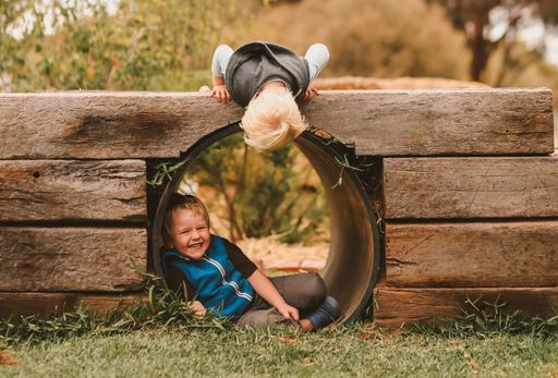 A closeup shot of two white Caucasian young kids playing together in a park