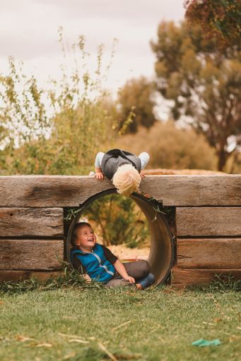 A vertical shot of two white Caucasian young kids playing together in a park