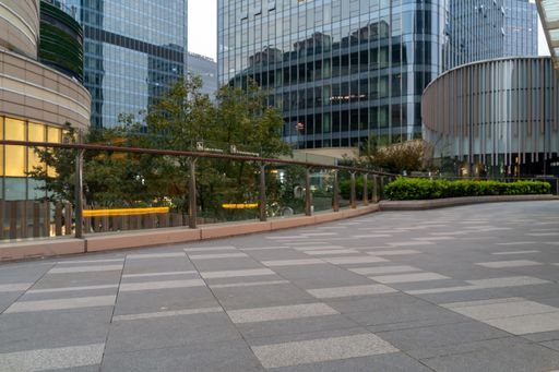 Empty concrete floor in front of modern buildings in the downtown street. copy space for a car advertisement.
