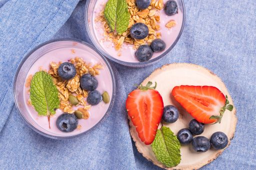 Top view of a healthy breakfast made with blueberries, strawberries and cereals with creamy yogurt. Natural yogurt with fresh berries and oatmeal