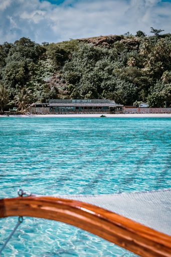 An idyllic landscape featuring a tranquil blue lake surrounded by a lush, green forest-covered hill