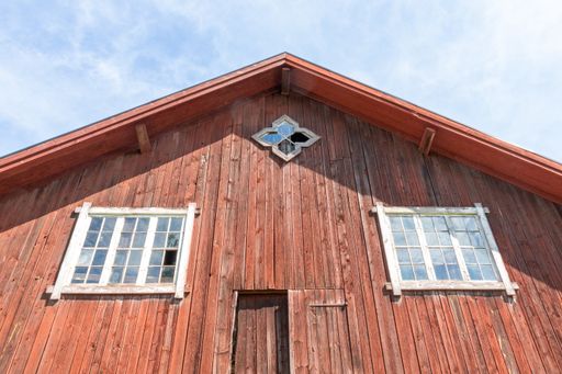 A low angle shot of a big wooden house with an outside glass windows