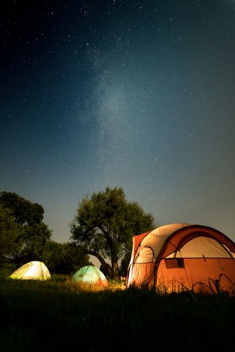 A starry night and tents on a green field