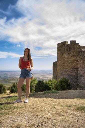 A young Spanish woman with brown hair in a medieval castle