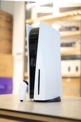 A Sony PlayStation 5 in a brightly lit retail store, on a table