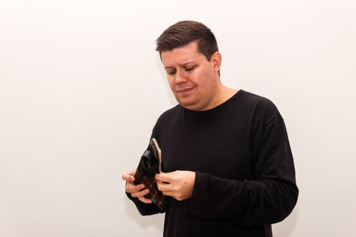A Caucasian male holding his empty wallet against white background