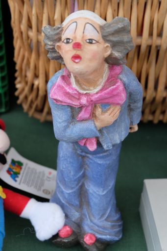 A vertical shot of a clown statue with a blurred background