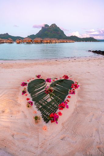 A romantic heart-shaped design made out of palm leaves on the beach. Bora Bora, French Polynesia