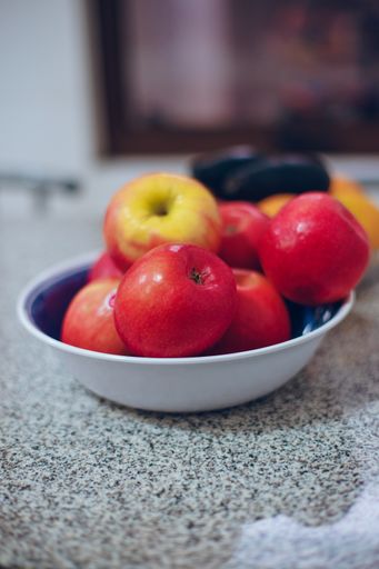 A closeup shot of a bowl of red fresh apples on a kitchen table
