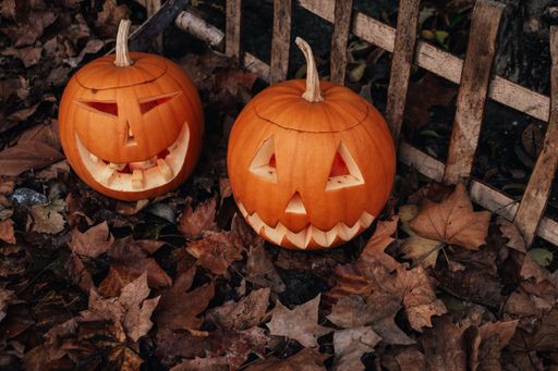 jack-o-lantern, two halloween pumpkins on a background of dried leaves