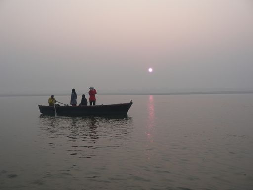 A shot of the tourists watching the sunset on a boat on the river Ganges in India.