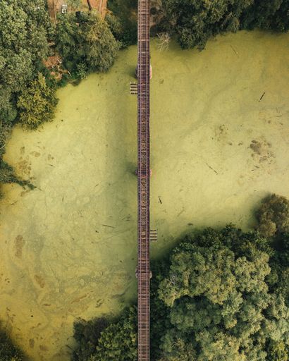 An aerial top view of a bridge crossing over a river
