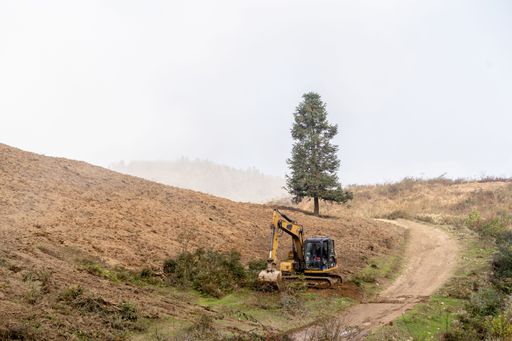 An excavator working in the field and digging the earth