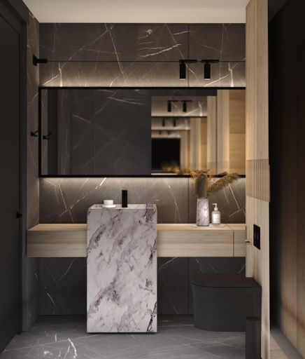 A marble vanity basin sits in a modern bathroom interior, accented by a large rectangular mirror