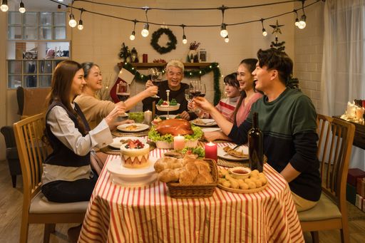 An Asian family capturing special moments around a table laden with Thanksgiving and Christmas culinary treasures