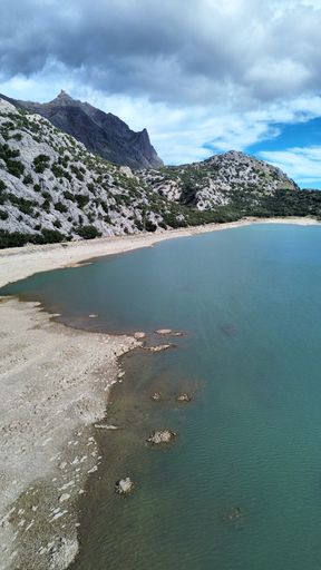 A scenic view of a lake surrounded by lush green mountains
