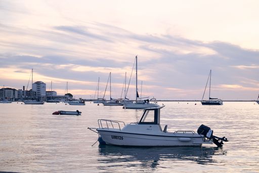 A series of small boats moored in the harbor at sunset. Croatia, Umag