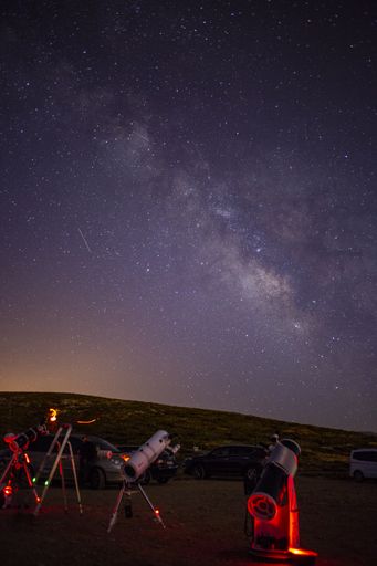 A vertical shot of  telescopes under a starry sky